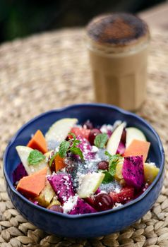 exotic mixed tropical asian fruit salad with basil seeds and coconut in bowl outdoors