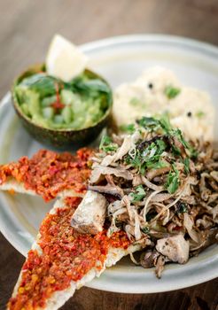 modern mexican brunch of  fried mushrooms with guacamole and spicy red pepper paste toast and scrambled eggs