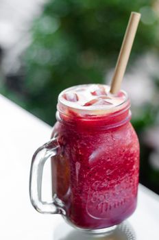 beetroot and carrot healthy organic vegetable smoothie outdoors in glass jar