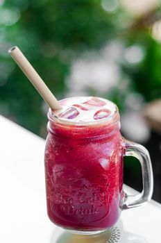 beetroot and carrot healthy organic vegetable smoothie outdoors in glass jar