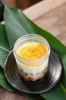 granola, coconut mousse, dates and turmeric powder healthy vegan dessert in rustic outdoors setting