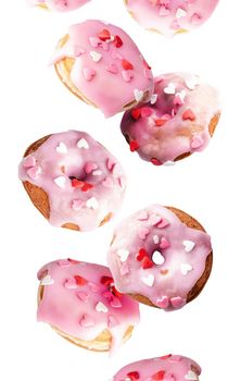 Valentine's Day. Flying donuts. Sweet pink donuts with heart sprinkles flying isolated on white background