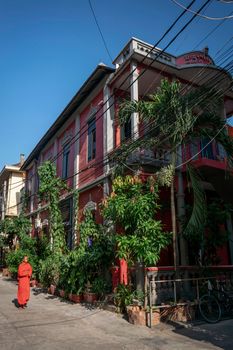 young buddhist monk walking in sunny phnom penh cambodia street inside the Wat Ounalom monastery complex