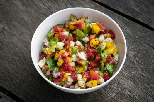 bowl of organic salsa salad on rustic old wood backgrond