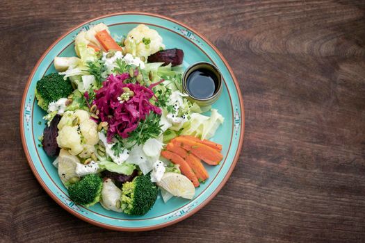 rustic cottage salad with healthy mixed steamed and fresh vegetables on colorful plate