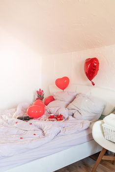 white romantic Valentine's Day bedroom with red hearts baloons