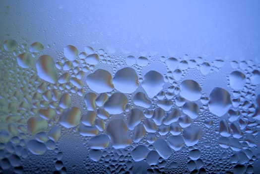 Water droplets or condensation on the outside of a cold windows in a close up full frame background texture