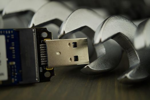 Set of spanners or wrenches in close up with jaws around a small electronic component and selective focus, technical support or smart tools concept