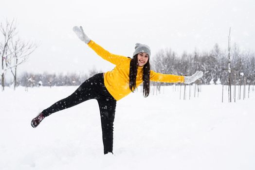 Outdoor concept. Young brunette woman playing with snow in park