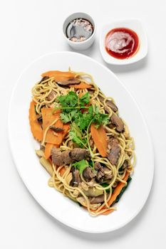 traditional khmer spicy beef stir fry with egg noodles and vegetables in cambodia on white studio background