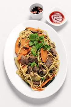 traditional khmer spicy beef stir fry with egg noodles and vegetables in cambodia on white studio background