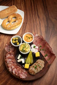 german cold cuts tapas snack platter with meats and bread on wood table background