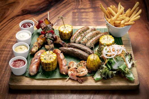 organic mixed grill barbecue meat platter rustic set meal with sausages, skewers, side dishes and sauces