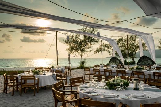 romantic wedding table design at sunset outside on tropical asian beach in bali indonesia