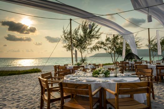 romantic wedding table design at sunset outside on tropical asian beach in bali indonesia