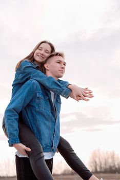 Happy young loving couple embracing each other outdoors in the park having fun