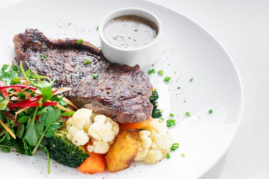 premium beef steak with steamed vegetables and mushroom sauce gourmet meal on white plate