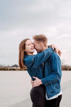 Happy young loving couple embracing each other outdoors in the park having fun