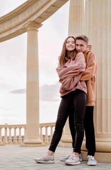 Happy young loving couple embracing each other outdoors in the park having fun