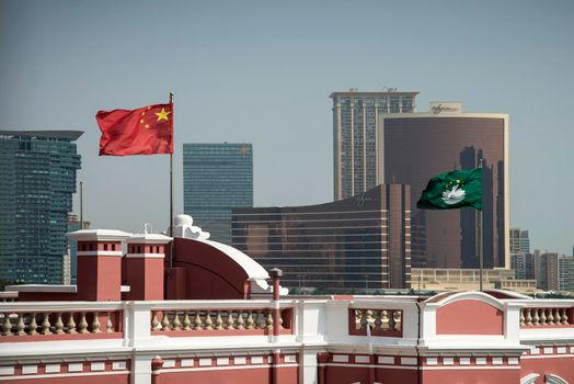 china and macau flags on chinese government headquarters building in downtown macau city