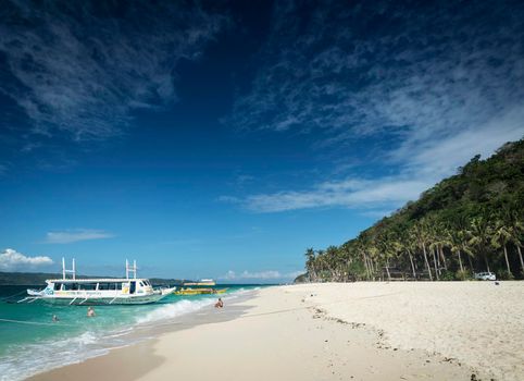 tourist boats on puka beach resort in tropical paradise boracay island Philippines
