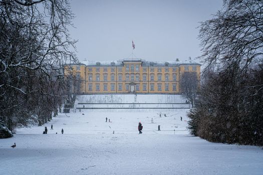 Copenhagen, Denmark - January 06, 2021: People enjoying a snowy winter day in front of the palace in Frederiksberg Gardens