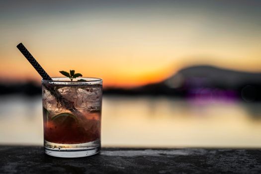 strawberry caipirinha mixed cocktail drink in riverside vientiane laos outdoor bar at sunset