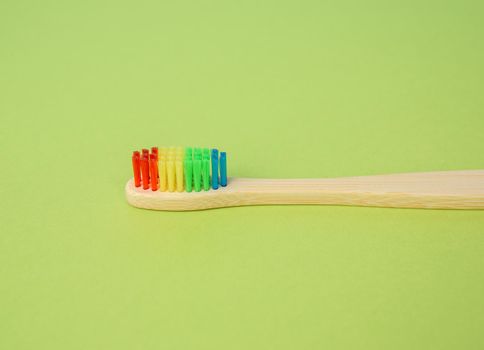 bamboo brush for cleaning teeth on a green background, plastic rejection concept, zero waste, close up