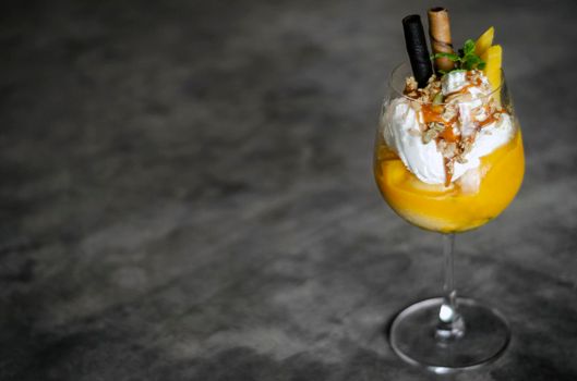 organic mango and passion fruit tropical ice cream sundae in wine glass