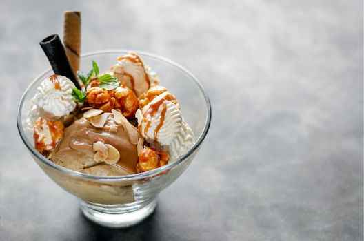 caramel and almond ice cream with caramelized popcorn sundae dessert in glass bowl