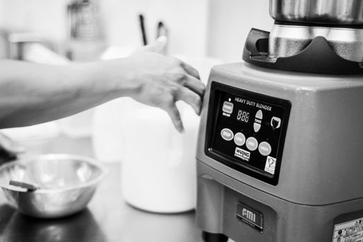 making gelato ice cream with modern professional equipment preparation detail in kitchen interior black and white photo