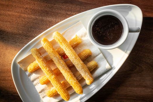 churros con chocolate traditional spanish sweet breakfast set on wooden table