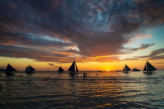 beautiful tropical sunset with sailing boats and tourists in boracay island philippines