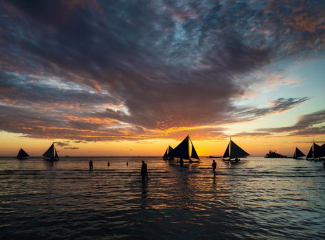 beautiful tropical sunset with sailing boats and tourists in boracay island philippines