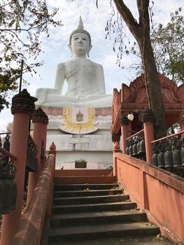 Stairs towards a big buddha statue in Phanom Sawai Forest Park Thailand

