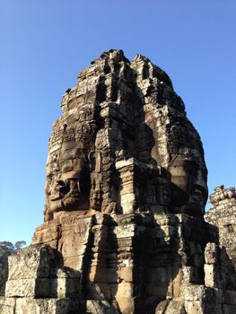 Smiling faces carved into stone walls of Bayon Temple in Krong Siem Reap, Cambodia