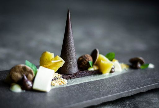 gourmet modern creative chocolate cake and dried fruit dessert dish on slate