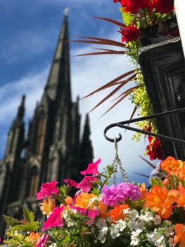 Colorful flowers with the Hub, Assembly Hall in the background in Edinburgh, Scotland
 
