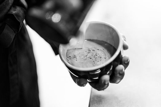 making espresso coffee BW black and white close up detail with modern cafe machine and glasses