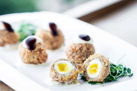 gourmet organic scotch quail eggs modern starter snack dish on table