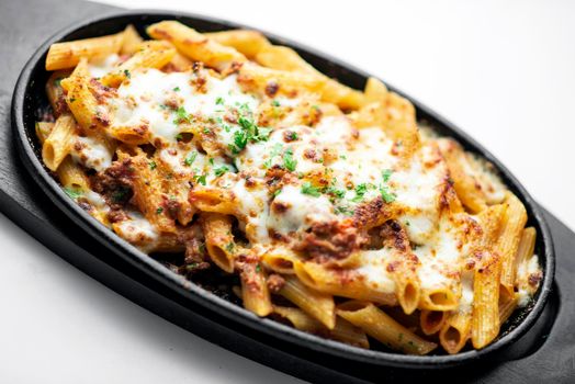 gourmet oven baked fresh pasta penne bolognese and mozzarella cheese dish