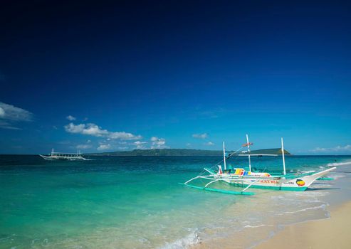 traditional boats on tropical puka beach in boracay philippines