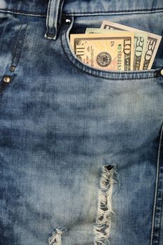 Close up several different value US dollar paper currency banknotes in jeans front pocket, low angle view