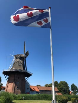 Frisian flag and the Windmill in Burdaard Friesland The Netherlands