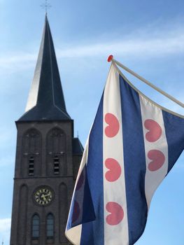 The frisian flag with the Sint Werenfriduskerk a church in Workum, Friesland, The Netherlands