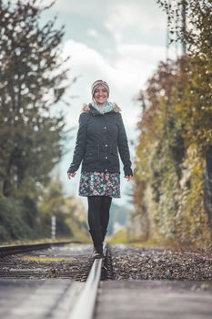 Girl waking on abandoned railroad, autumn