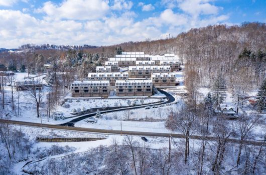 View of modern townhouses covered with winter snow on hill overlooking Cheat Lake near Morgantown West Virginia