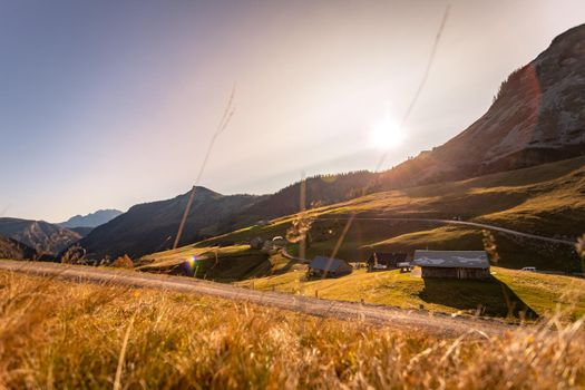 Beautiful scenic mountain scenery with huts and warm colors, sundown