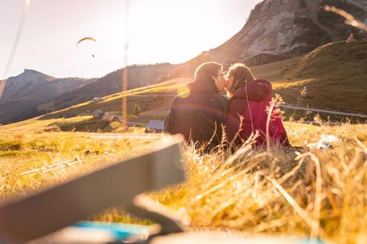 Couple in sportswear is enjoying the sunset in the mountains: sitting on the ground and enjoying the view. Alpes, Austria