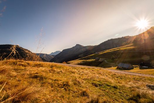 Beautiful scenic mountain scenery with huts and warm colors, sundown